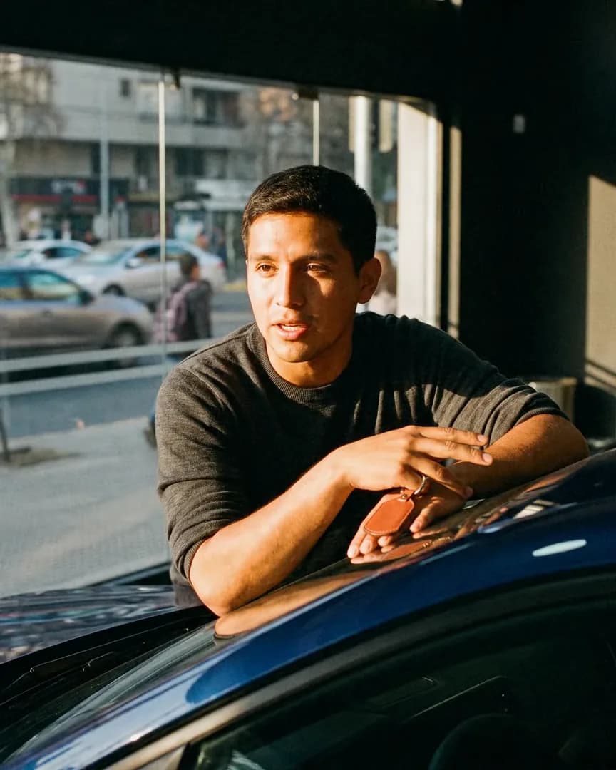 El dueño joven de una automotora atiende a un cliente en el salón.