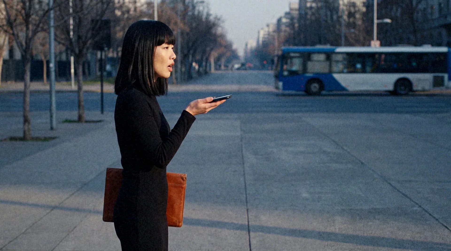 A woman talks into her phone on speaker, held flat on her palm.